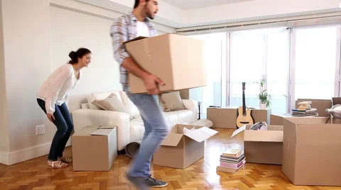 Attractive couple moving boxes into their living room 스톡 동영상 41038648
