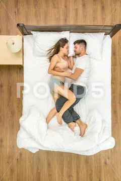 The attractive couple sleeping on the bed. View from above Stock Photos