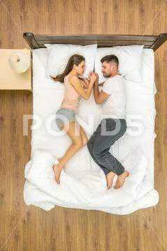 The attractive couple sleeping on the bed. View from above Stock Photos