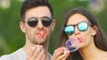 The attractive couple in sunglasses blowing bubbles. slow motion 4k or 4k+ Resolution