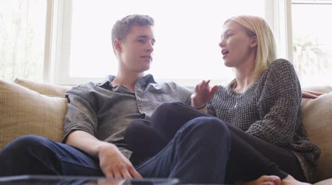 Attractive couple talking on couch 库存影片 51559119