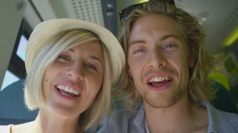 Attractive couple on a train talking to camera as a video call in slow motion Stock Footage 51895403