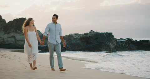 Attractive couple walking on the beach together Stock Footage 116267622