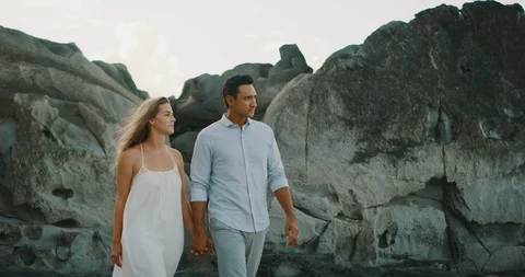 Attractive couple walking on the beach together Stock Footage 116269130