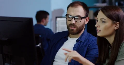 Attractive couple of young office workers working on a business project at the Stock Footage 82447700