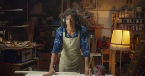 Attractive curly carpentry master guy standing at cozy workshop leaning at work Stock Footage 140544140