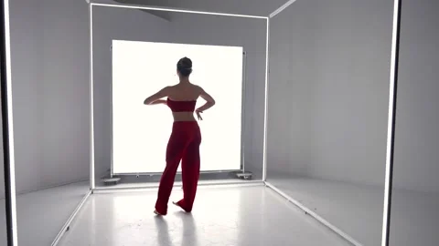 Attractive dancer lady is moving against glowing panel in modern studio Vidéo 179845239