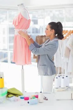 Attractive designer adjusting dress on a mannequin Stock Photos