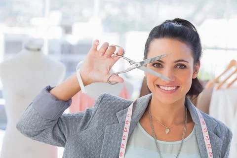 Attractive designer holding scissors in front of her face Stock Photos