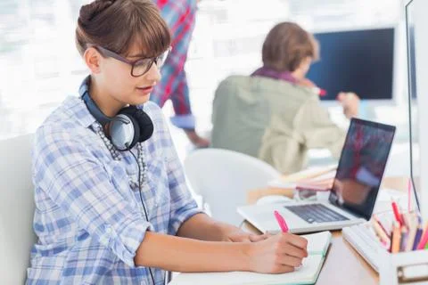 Attractive designer writing on a notepad Stock Photos