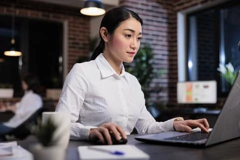 Attractive developing agency employee sitting at desk in office workspace while Stock Photos