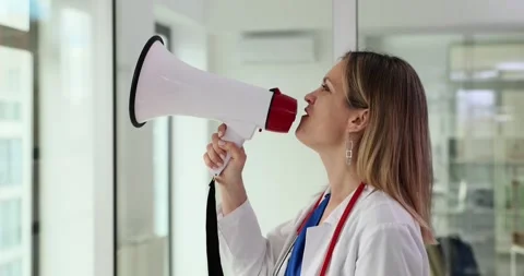 Attractive doctor shouts instructions using loudspeaker Stock Footage 267661700