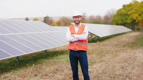 Attractive ecological engineer man at modern solar panels farm posing in front Stock Footage 164551887