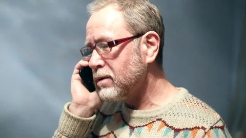 Attractive elderly caucasian man with beard eyeglasses talking emotionally phone Видео 112241734