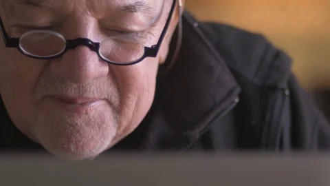 An attractive elderly senior man reading aloud from his laptop Stock Footage 71942724