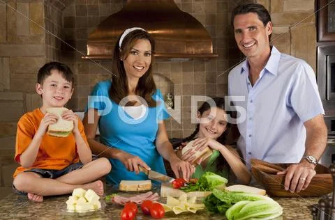 Attractive family in kitchen making healthy sandwiches Stock Photos