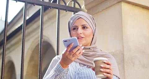 Attractive female arab using smart cellphone, chatting with friend family Stock Footage 167125476
