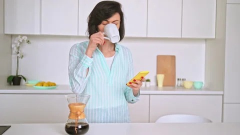 Attractive female chatting using mobile at home Stock Footage 157162546