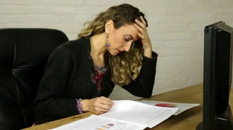 Attractive female hispanic executive looking at graphs and statistics on desk Stock Footage 47804163