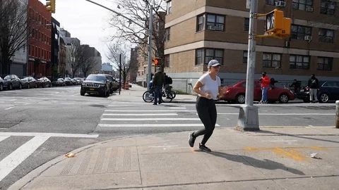 Attractive Female Jogs Through Low Income Neighborhood Stock Footage 128085683