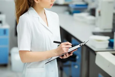 Attractive female lab worker making medical research in modern laboratory Stock Photos