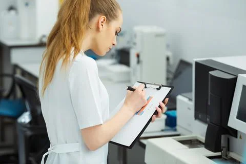 Attractive female lab worker making medical research in modern laboratory Stock Photos