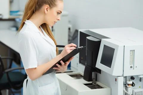 Attractive female lab worker making medical research in modern laboratory Stock Photos