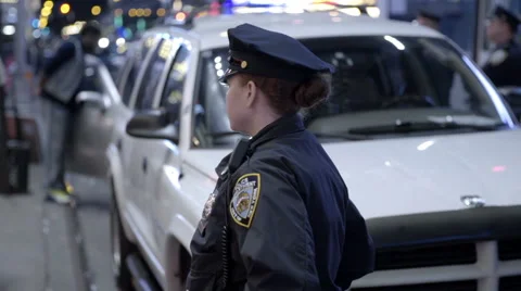 Attractive female police officer in uniform night slow motion Times Square NYC Stock Footage