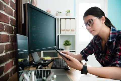 Attractive female programmer using mobile pad Stock Photos