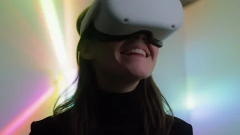 Attractive female puts on VR virtual reality headset emotionally looks around Vídeos de archivo 242092674