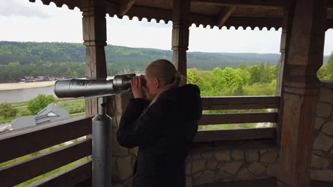 Attractive female traveller using Tower Optical viewer for looking around valley Stock Footage 133801550