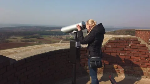 Attractive female traveller using Tower Optical viewer for looking around valley Stock Footage 133803653