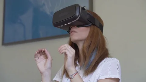 Attractive female wearing VR headset and experiencing virtual reality Stock Footage 80944357