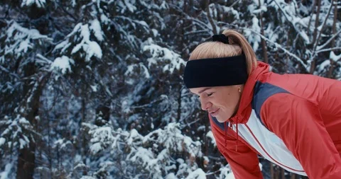 Attractive fit Caucasian female catching breath while jogging in winter forest Vidéo 85716880