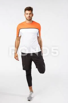 Attractive football player warm-up muscles before match. Serious-looking Stock Photos