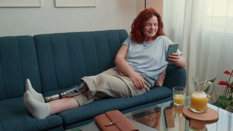 Attractive freelancer coach woman with bionic leg prosthesis waves talking to Stock Footage 186190879