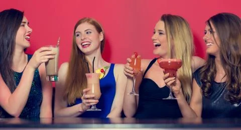 Attractive friends clubbing holding cocktails Stock Photos