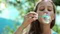 Attractive girl blowing soap bubbles HD Footage