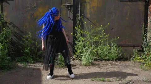 Attractive girl with blue dreadlocks dancing on the street, shaking dreadlocks Stock Footage 78096678