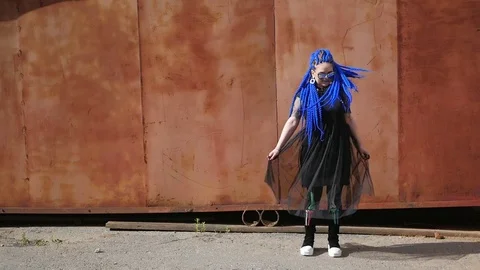 Attractive girl with blue dreadlocks dancing on the street, shaking dreadlocks Stock Footage 78097483