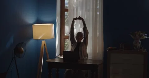 Attractive girl finished computer work and stretching at workplace at home Stock Footage 203680212