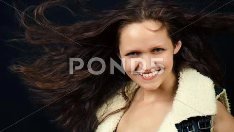 Attractive girl with long hair in denim vest Stock Photos