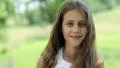 Attractive girl with long hair looks at the camera HD Footage