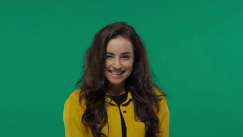 Attractive girl is looking at the camera shyly. She is smiling playfully. on Stock Footage 142364341