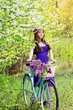 Attractive girl on an old-fashioned retro bike. Stock Photos