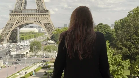Attractive girl posing at the Eiffel Tower in Paris after work, with a black Stock Footage 111924947
