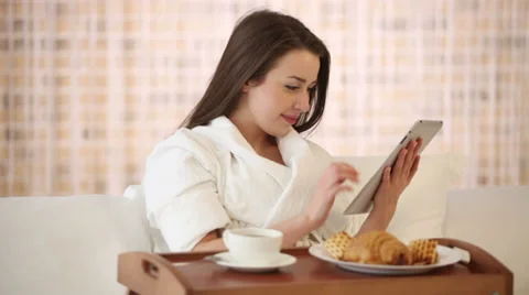 Attractive girl sitting in bed using touchpad looking at camera and smiling Video stock 30949551