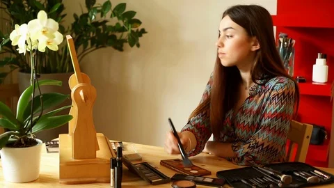 Attractive girl using bronzer to contour her face  Video stock 73683349