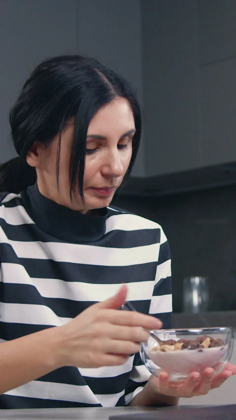 Attractive in good mood 30-aged black-haired housewife sitting at kitchen table  Stock Footage 326770894