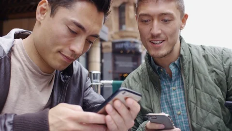 Attractive group of asian people using their phones at a cafe table Stock Footage